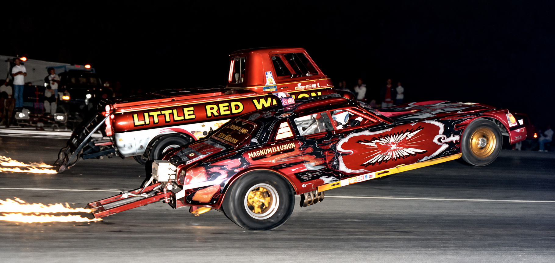 Magnum Illusion and Little Red Wagon performing side-by-side wheelstands at night
